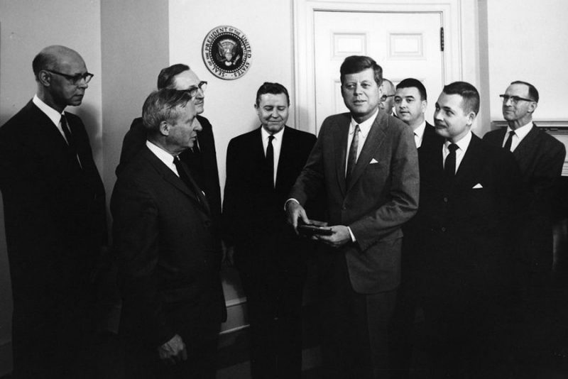 Bud Robertson stands in the White House with officials including President John F. Kennedy