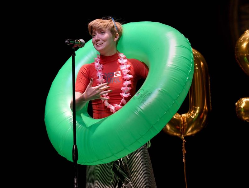 Mallory is wearing a large green blowup pool tube around her body as she shares her match