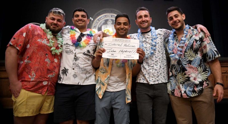 Five gentlemen all wearing Hawaiian style shirts. In the center is Yazan Alshawkani holding up the sign that says I matched into Internal Medicine at Johns Hopkins