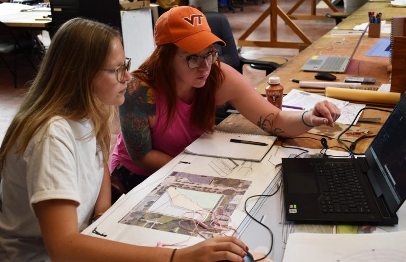 GTA and VT GrATE fellow Sara Lamb works with student image of two women -- Sara Lamb and Chelsea Brighton-Smith, focus on a computer screen as they discuss a design project
