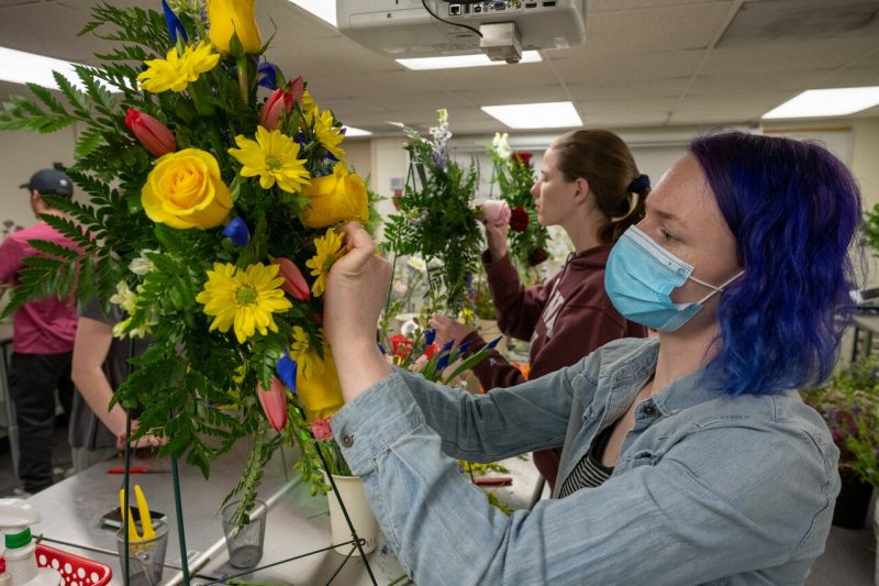 A floral design student works on a flower arrangement for the April 16 Memorial