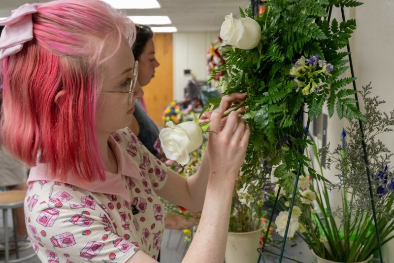 A floral design student works on a flower arrangement for the April 16 Memorial