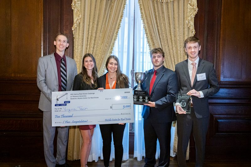 Five Virginia Tech team members pose with award check and trophy at the Mulroy Real Estate Challenge