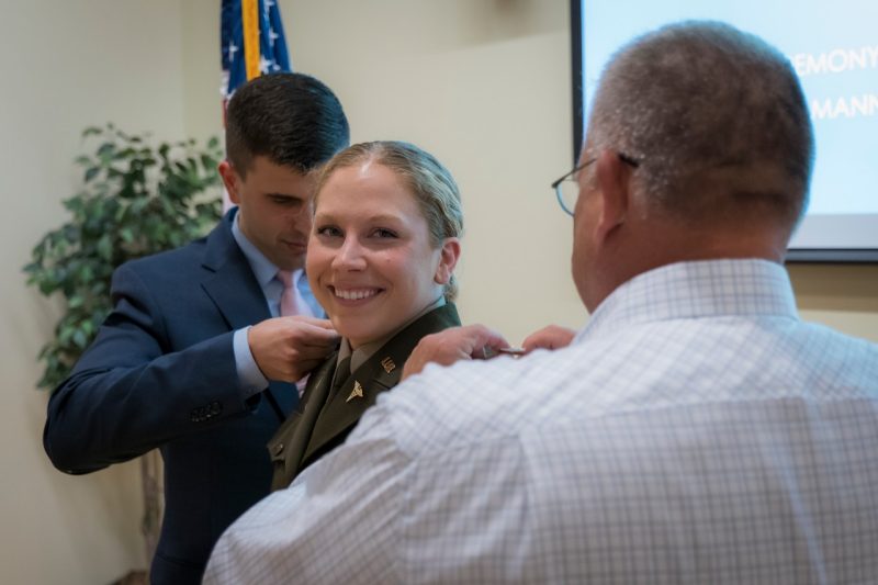 Dawn Wright Ullmann is has her pins added to her shoulders by her husband and father during her promotion to Captain in the U.S. Army.