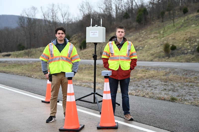 Two researchers standing with the smart work zone system