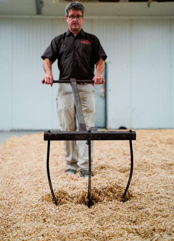 Asheville-based Riverbend Malt House co-founder Brent Manning is pictured using a traditional floor malting technique, which germinates the grains in a thin layer. The grain is manually raked and turned to keep the grains loose and aerated.