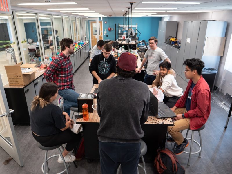 A team of engineering students gather around a table in the Prototyping Studio to work on their drone. Photo by Chase Parker for Virginia Tech