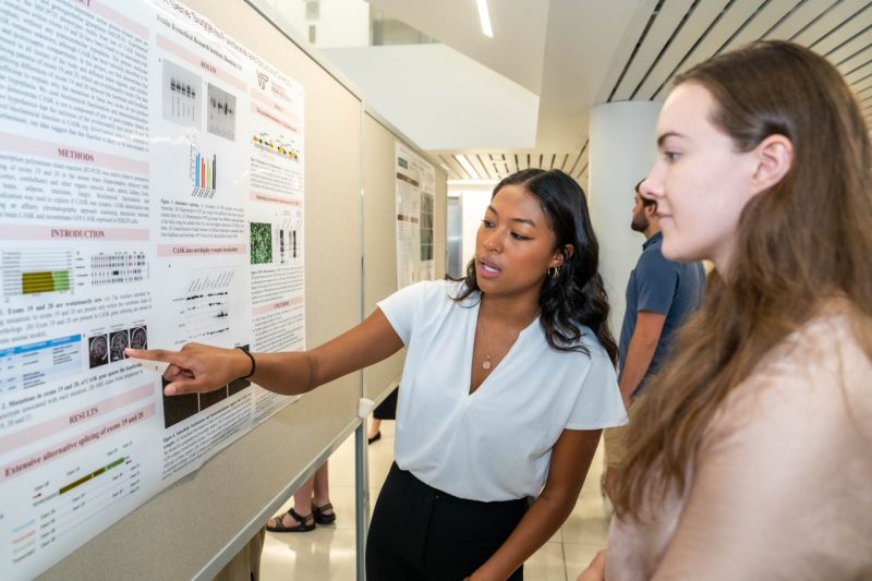 Sydnee Harrison describes her research poster at the Fralin Biomedical Research Institute at VTC's research symposium. 