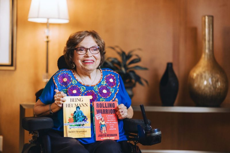 Judith Heumann poses with her books