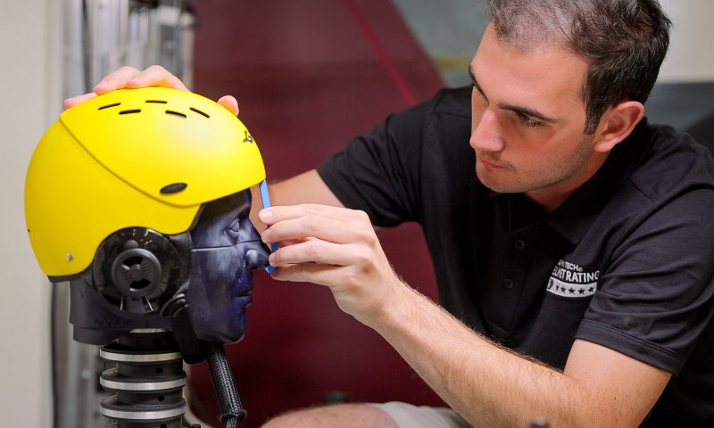 A student performs safety testing on a whitewater helmet. 