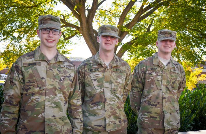  Cadets Bolin, Swafford, and Waugh stand in uniform smiling with a large Upper Quad elm tree in the background.