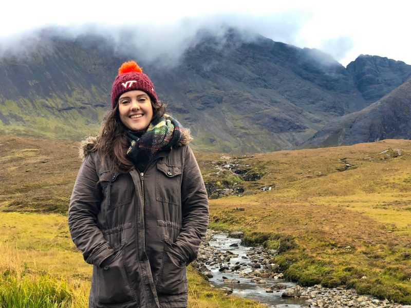 Leann Poirier standing in front of some mountains in Scotland