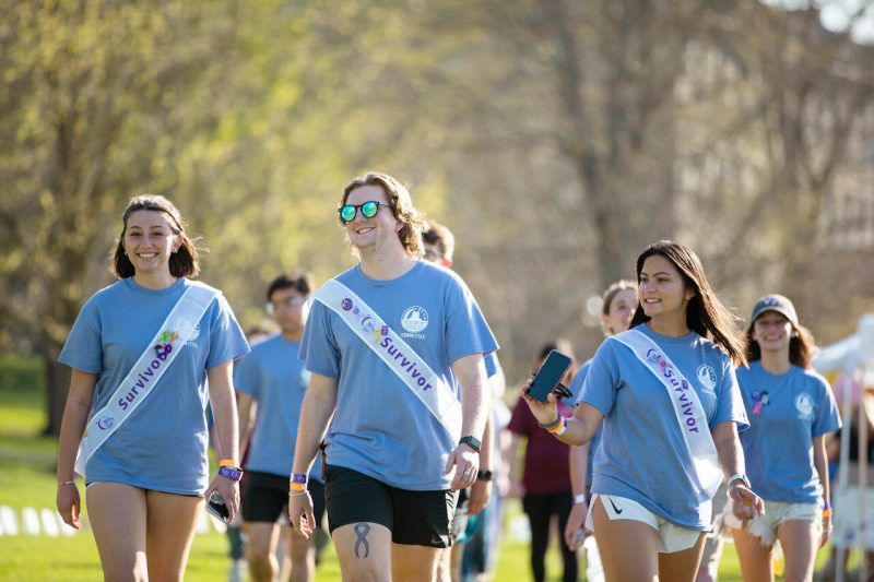 Collin Jesse (at center) wears as "survivor" sash as he and friends walk during the 2022 Relay for Life fundraiser on the Drillfield.  