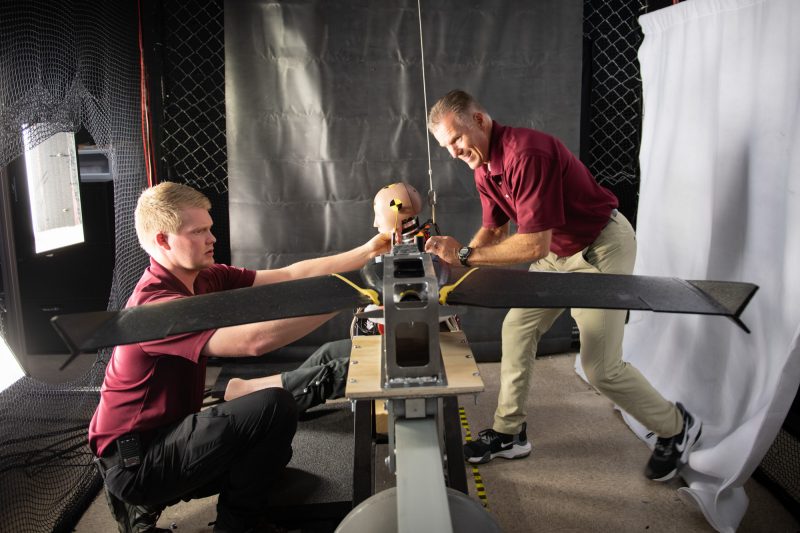 Two researchers set up an impact test for a drone. 