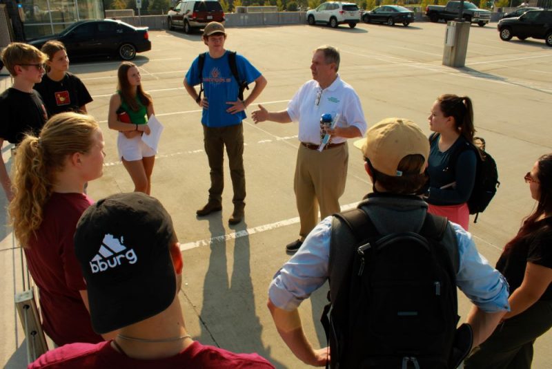Approximately a dozen real estate students on a tour on the Blacksburg campus with real estate department head Kevin Boyle