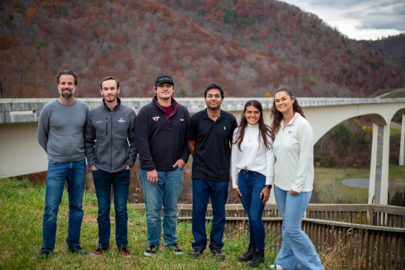 (From left) Zac Doerzaph, Andrew Galloway, Haden Bragg, Sparsh Jain, Jacqueline Chavez-Orellana, and Mariette Metrey standing in front of the Virginia Smart Roads at the Virginia Tech Transportation Institute