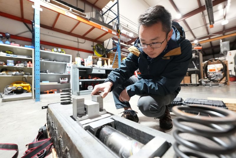 Yang Chen inspects an energy-harvesting rail in the Railway Technologies Laboratory.