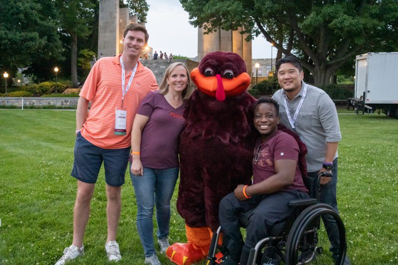 a group of people smiling on the Drillfield with the HokieBird