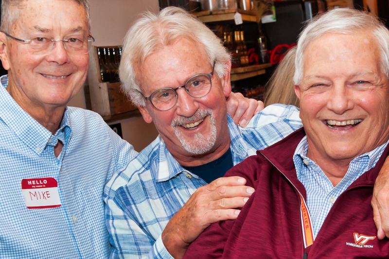 Three men standing together and smiling