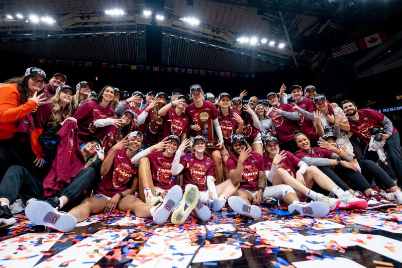 Members of the Virginia Tech Women's Basketball team pose with a trophy after having won their region to advance to the Final Four.