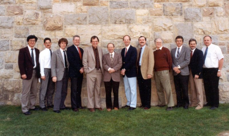 Group of men in computer engineering stand in front of building with Hokie Stone