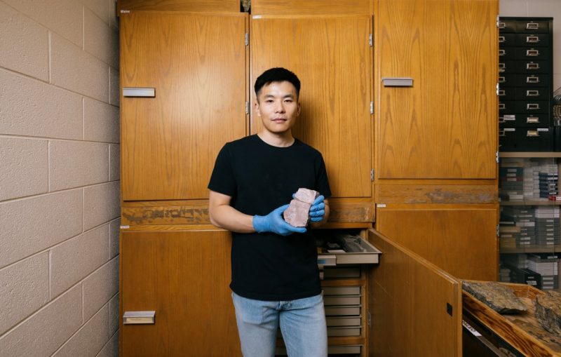 Junyao Kang holds a carbonate rock sample.
