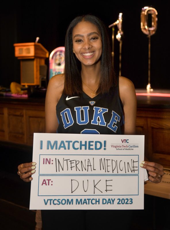 A VTCSOM student holds a sign announcing her match with Duke.