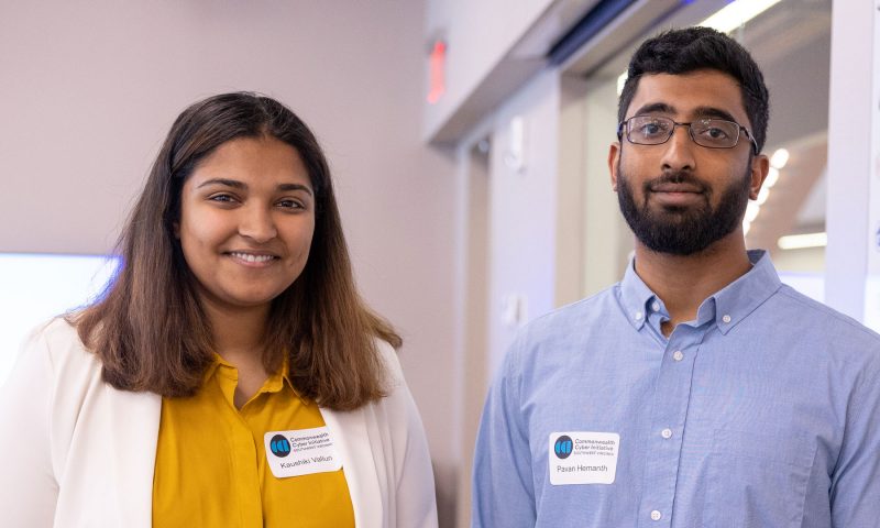 Two students smile at the camera