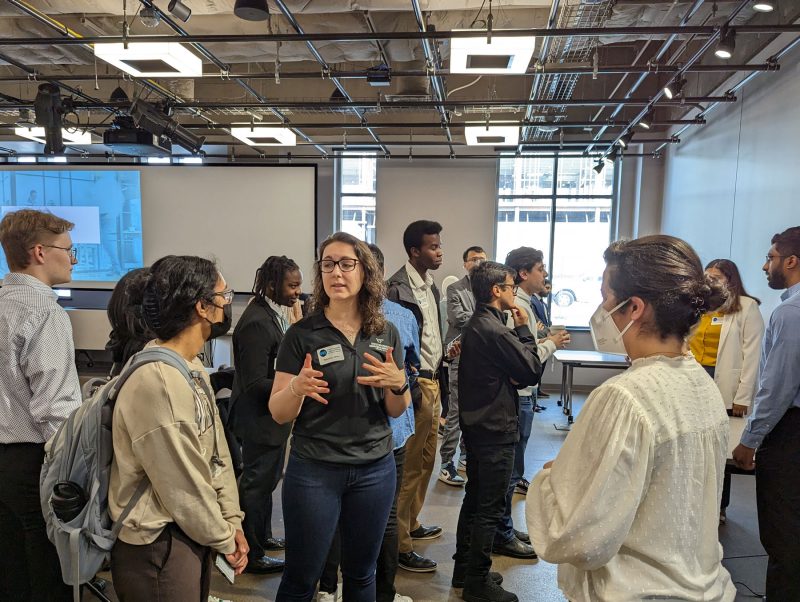 A large group of students interacting, gesticulating 