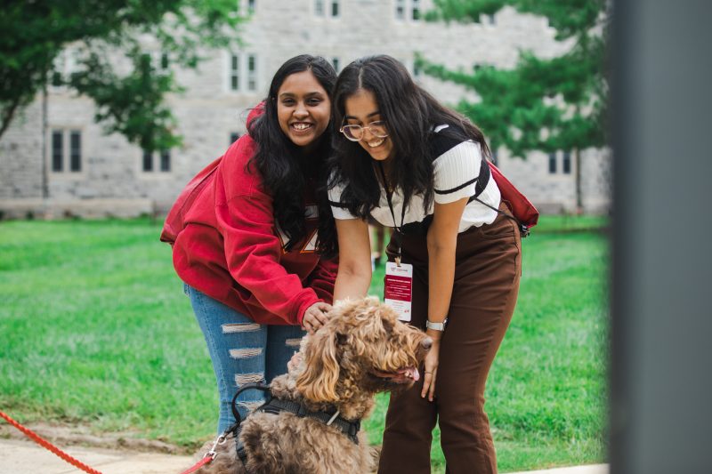 Two first-year students and a dog during Weeks of Welcome