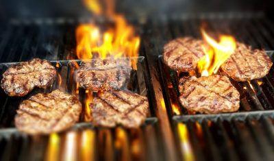 burgers on grill with flames
