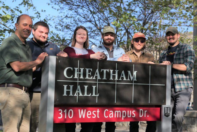 Six people stand around a sign that reads ‘Cheatham Hall.’
