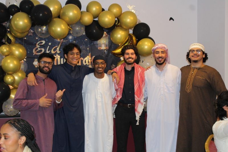 Muslim Association students pose in front of a backdrop with balloons during xxxxx event