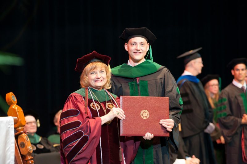Robert Summey holds his diploma with former dean Cynda Johnson as the 2015 Virginia Tech Carilion School of Medicine graduation.