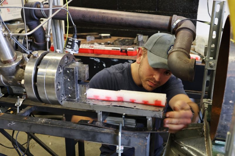 Master’s student Ethan Schlussel prepares a 2D optically accessible chamber on a solid fuel ramjet rig for experimental testing at the Advanced Propulsion and Power Laboratory. 