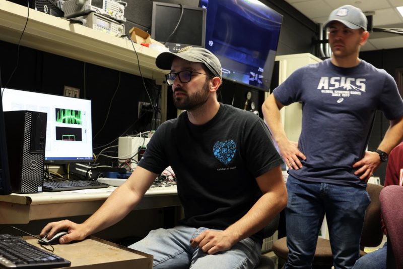 Ph.D. candidate Dominic Gallegos, left, and master’s student Ethan Schlussel review the footage and data captured in an experiment on the solid fuel ramjet rig. 