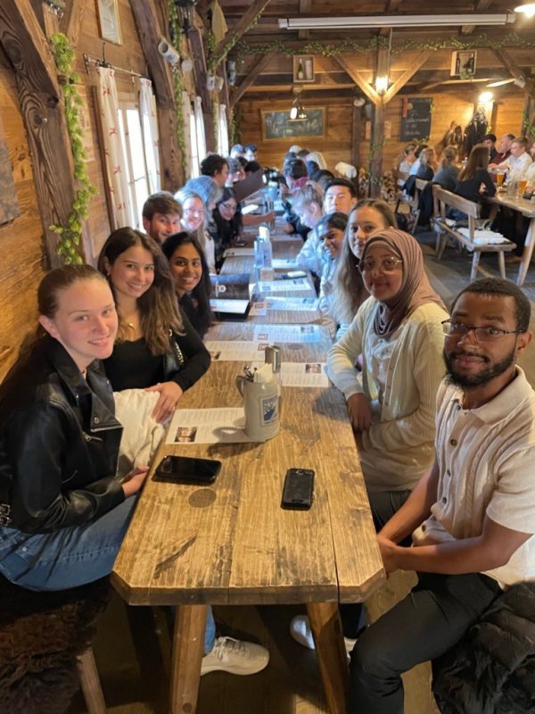Students enjoy dinner together at a large table in a German restaurant 
