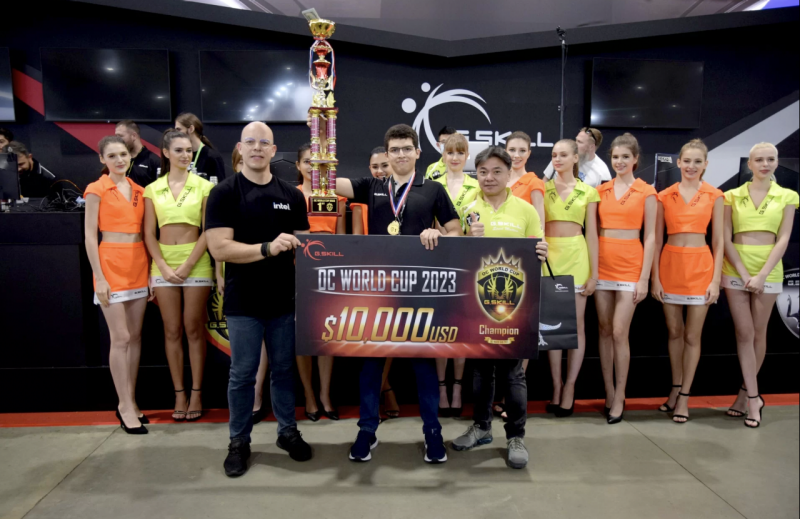 women stand in a line behind two men holding a large check and trophy at competition