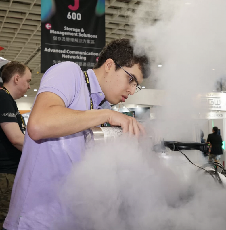 Competitor uses liquid nitrogen to cool down computer processor in a convention center.