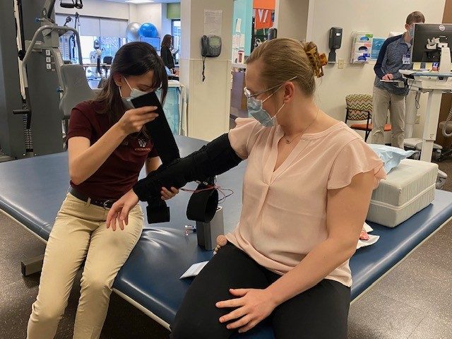 Laura Wenger '23 and Evgeniya Molotkova test the final version of the Lymphedema Wearable Device. Photo by Michelle Darby for Virginia Tech.