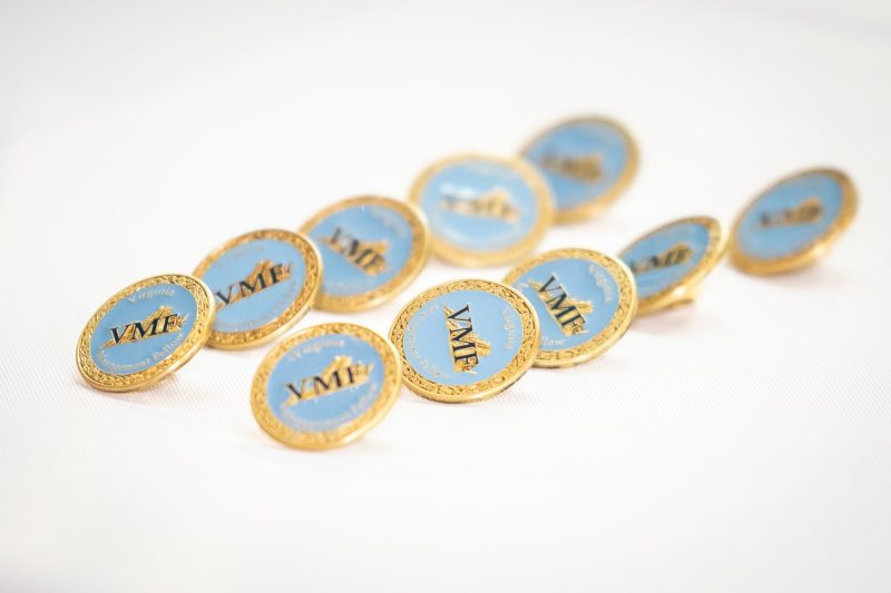 Small, round gold and blue pins are engraved with the state of Virginia and the VMF acronym. 