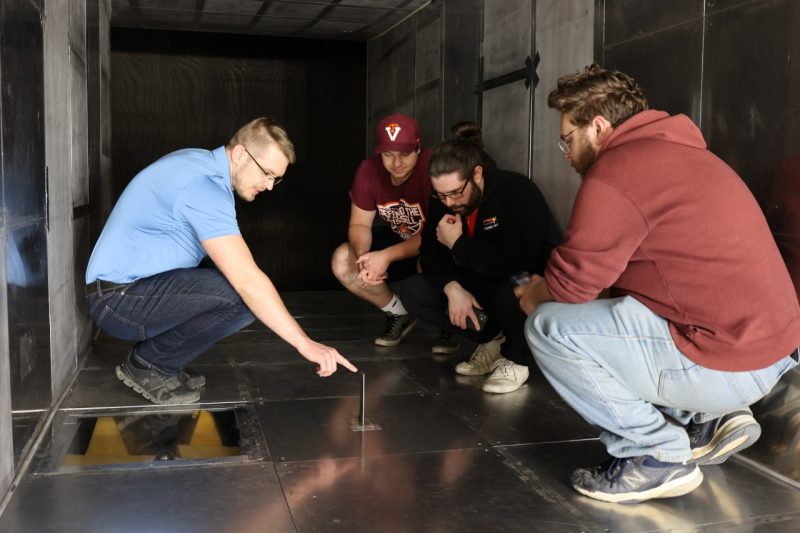 Senior research associate Mate Szoke works with three undergraduates in the test section of the Stability Wind Tunnel