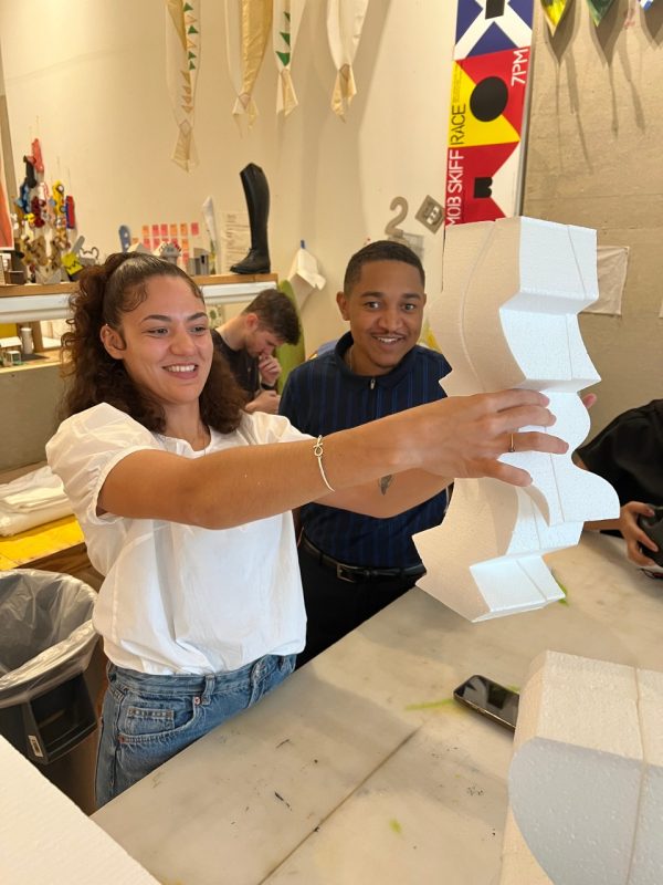 Female and male look at their fabricated column. 