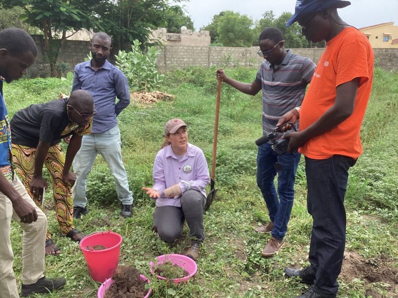 Woman in purple shirt leads a group of farmers in Senegal