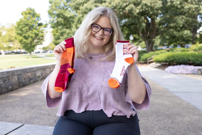 Madison Gunnell holding this year's Hokie socks designs.