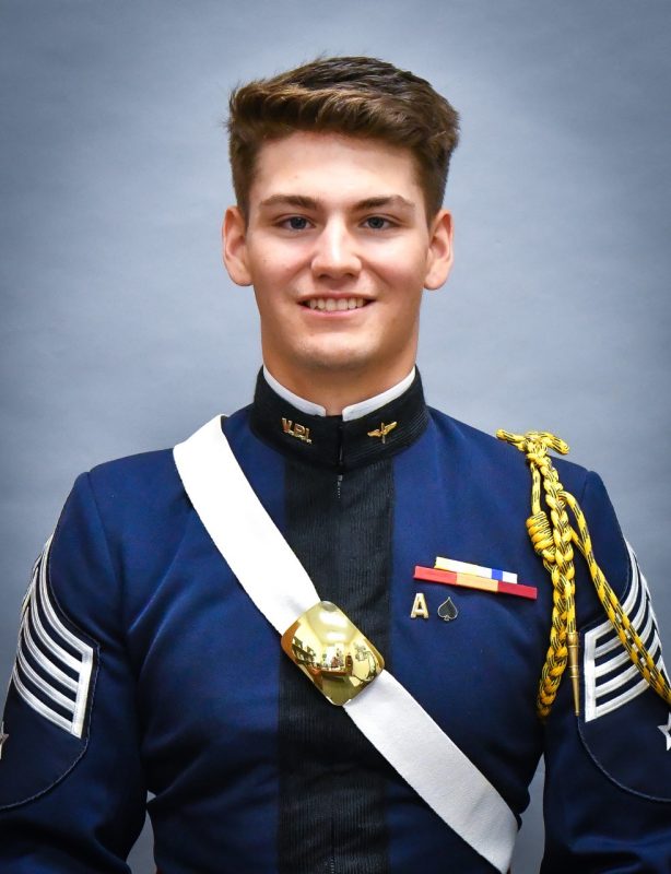 Portrait of Cadet Byrnes. His uniform blouse is blue and he is wearing a white crossbelt with a brass breastplate.