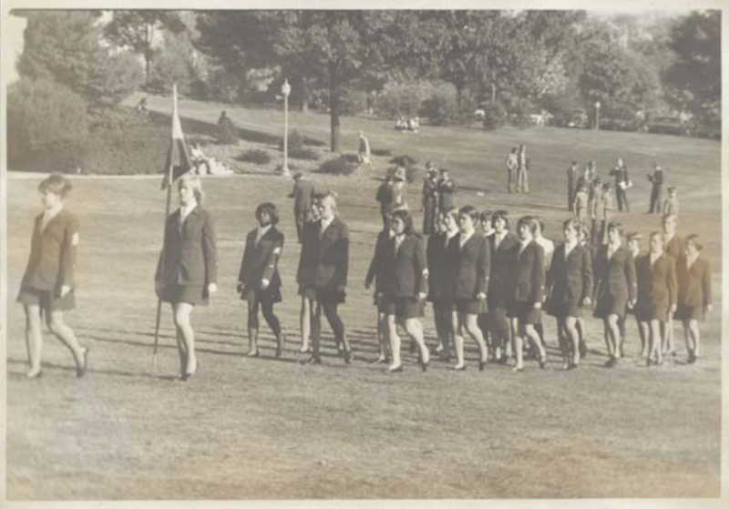 L Squadron marching on the Drillfield. They are in dark skirts, dress blouses, and pumps.