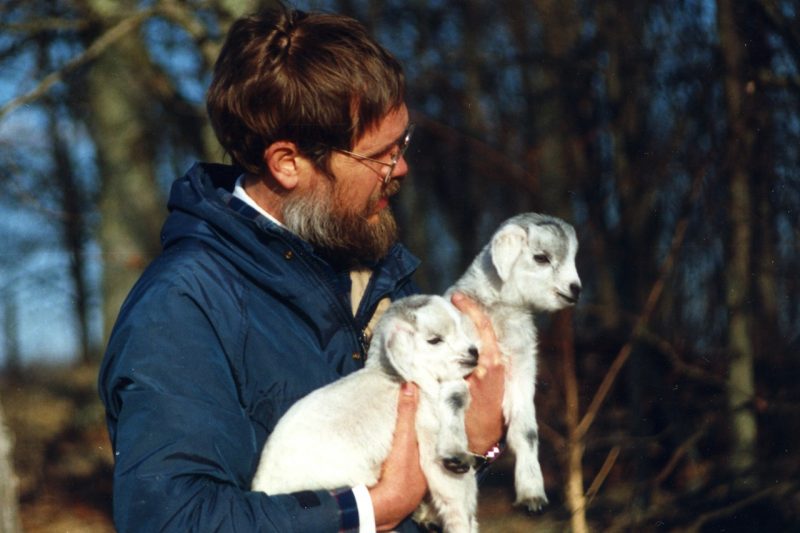 Person holding two baby goats.