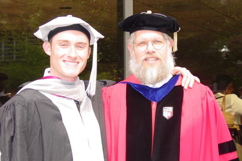 Two people in doctoral caps and gowns.