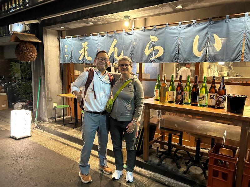 A man and a woman posing in front of a Tokyo restaurant